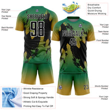 Laden Sie das Bild in den Galerie-Viewer, Custom Kelly Green Black Old Gold-White Gradient Splash Sublimation Soccer Uniform Jersey