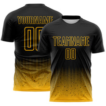 Laden Sie das Bild in den Galerie-Viewer, Custom Black-Gold Fade Wave Lines Splatter Sublimation Soccer Uniform Jersey
